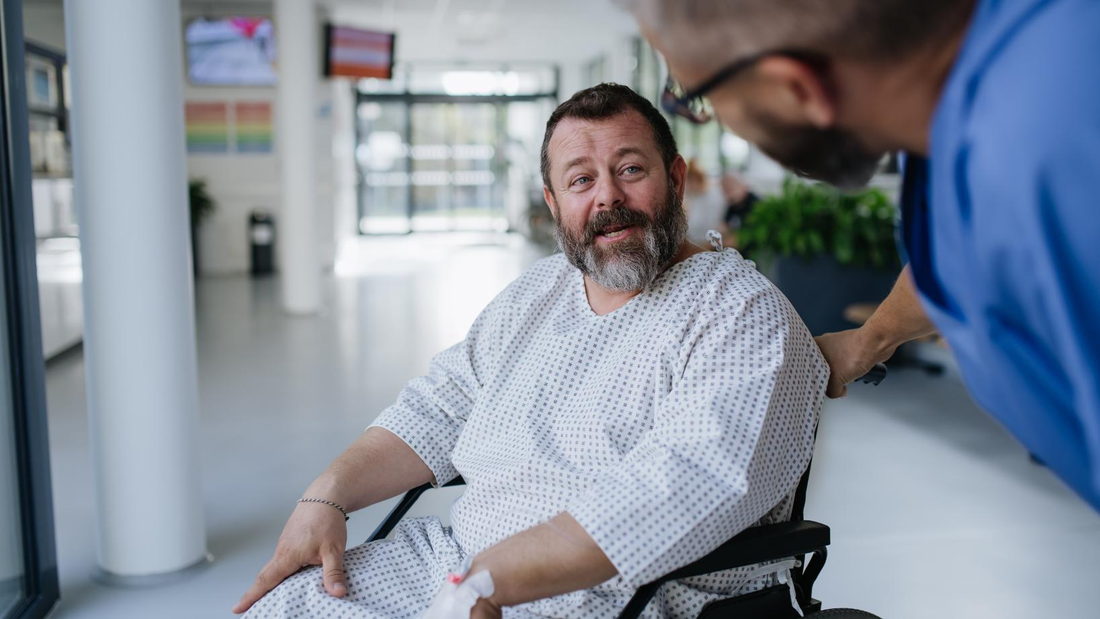 Man in wheelchair is given empathy by male clinician