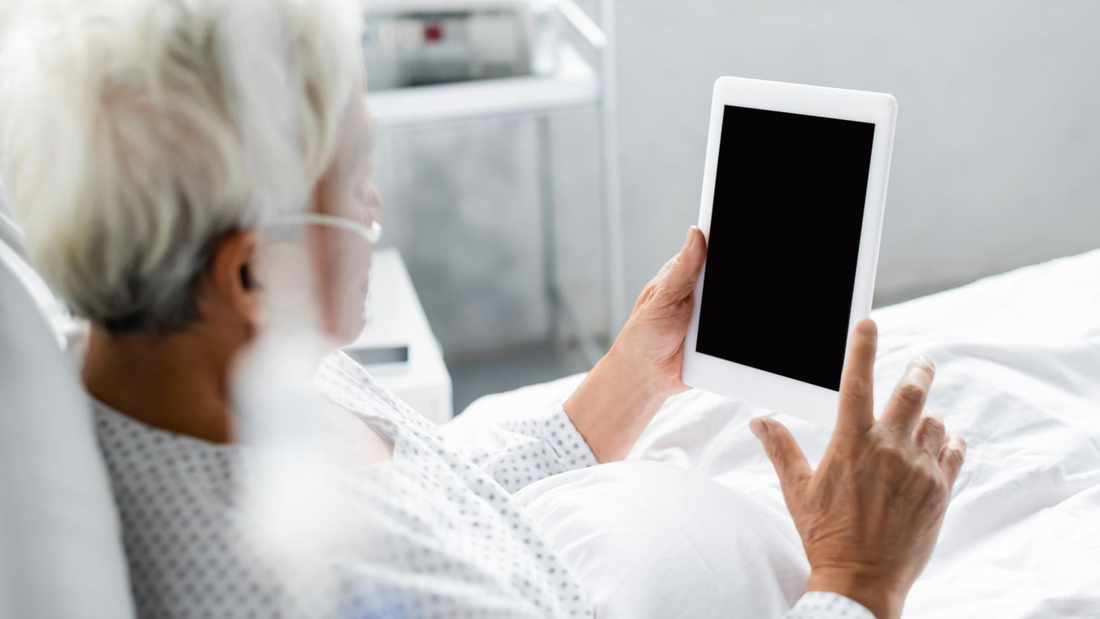 Patient watches an iPad from their hospital bed.